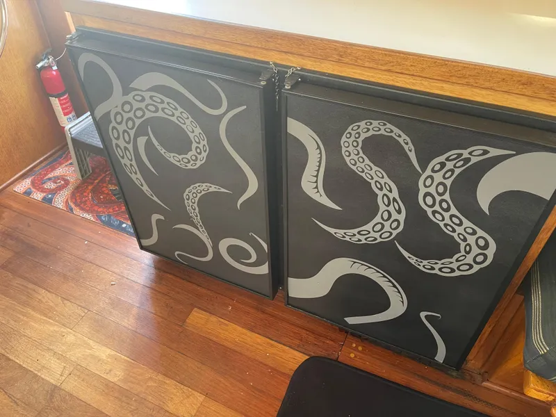 Slide: The Image of 1978 Californian Tri-Cabin Trawler interior with octopus tentacle art on black cabinet doors. - 34