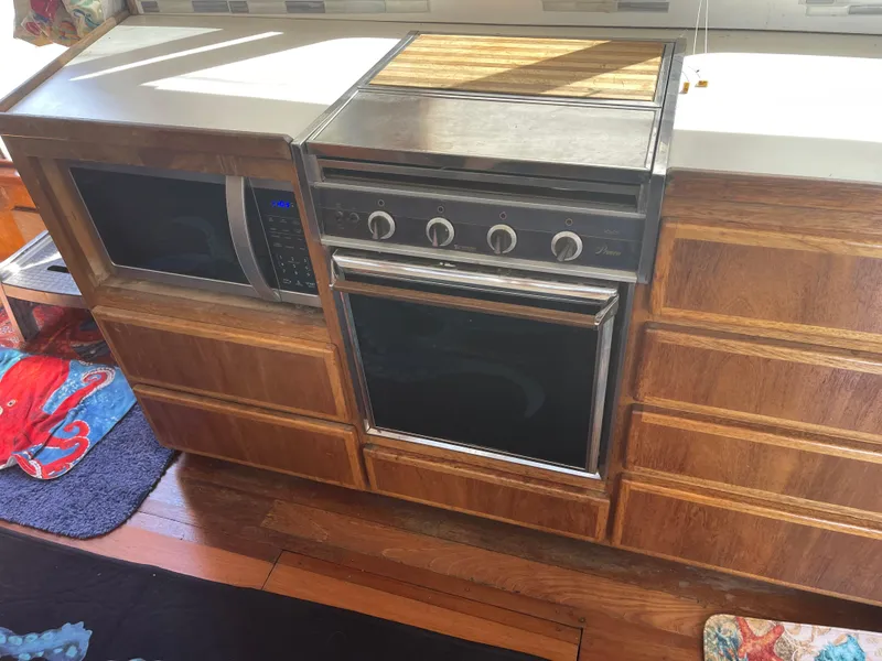Slide: The Image of 1978 Californian Tri-Cabin Trawler kitchen with wooden cabinets and built-in appliances. - 35