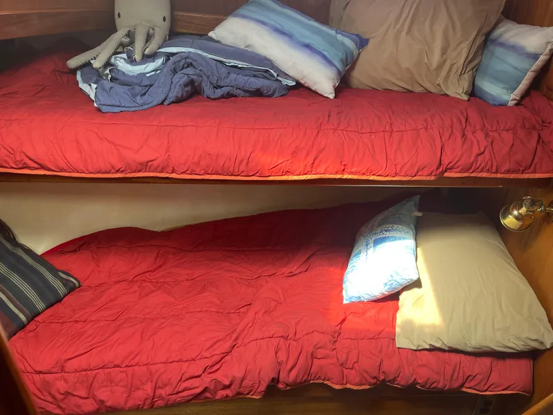Slide: The Image of Cozy bunk beds with red bedding in a 1978 Californian Tri-Cabin Trawler. - 36
