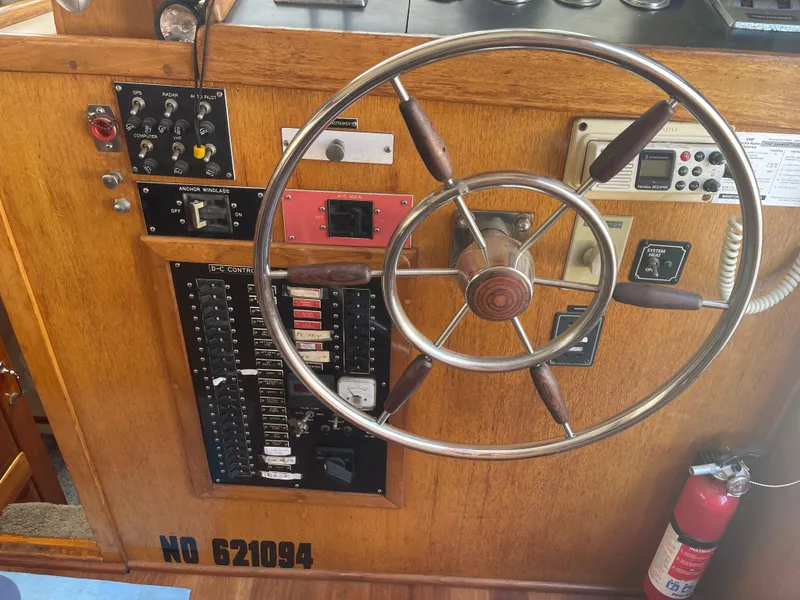 Slide: The Image of 1978 Californian Tri-Cabin Trawler helm with steering wheel, control panels, and fire extinguisher. - 37