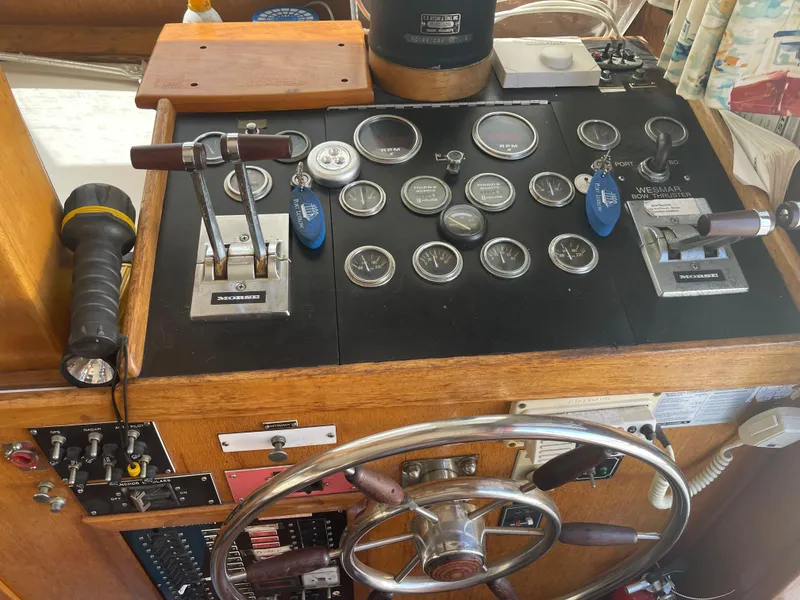 Slide: The Image of 1978 Californian Tri-Cabin Trawler helm with gauges, controls, and steering wheel. - 38