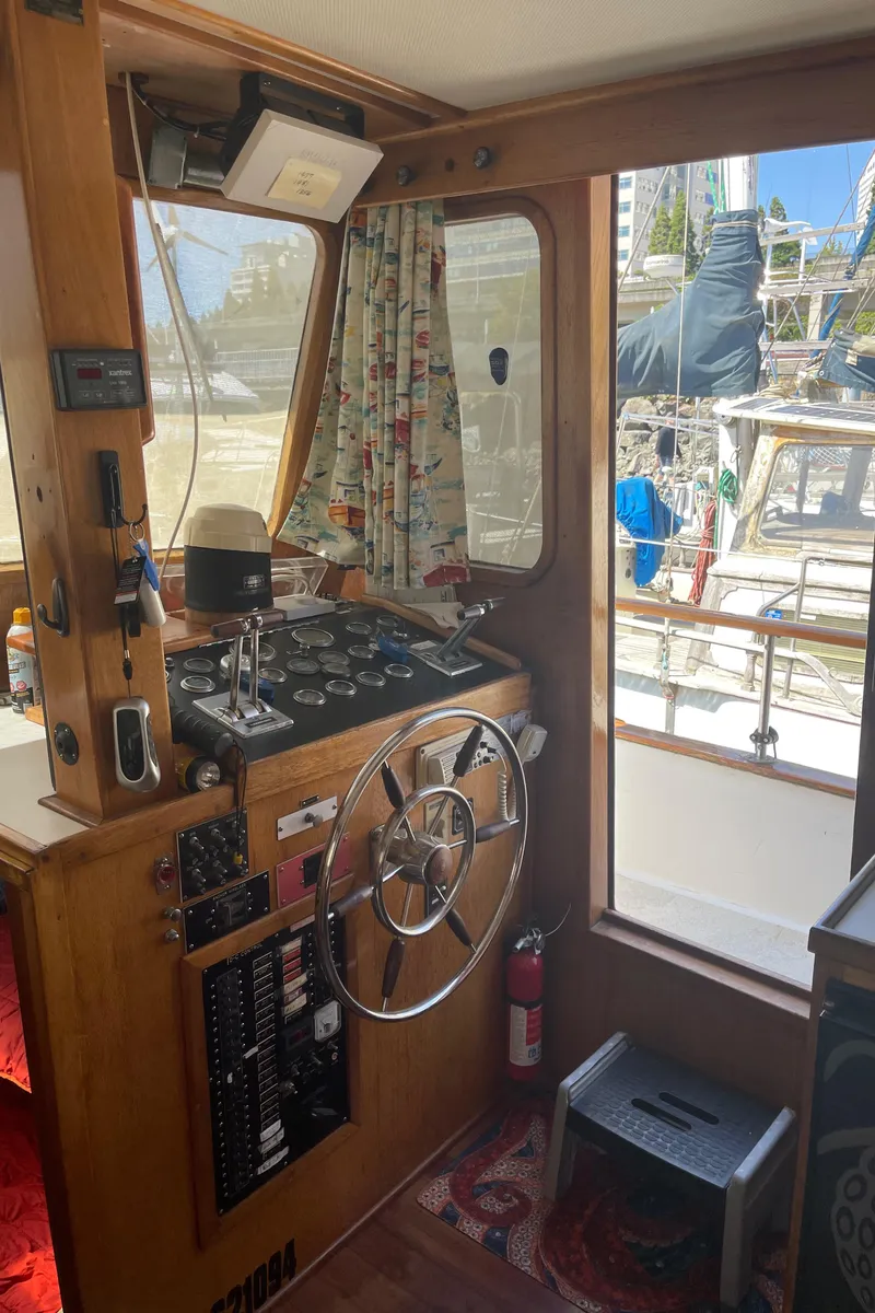 Slide: The Image of 1978 Californian Tri-Cabin Trawler helm with wooden interior and nautical instruments. - 46