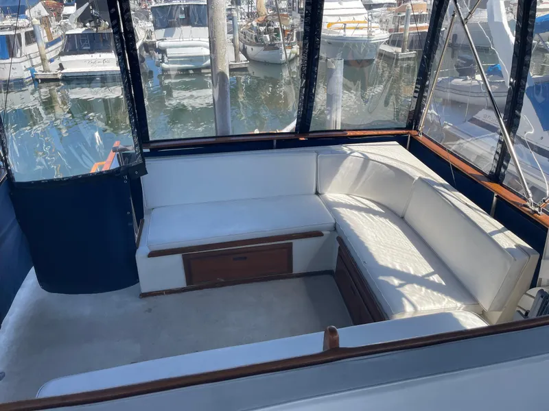 Slide: The Image of 1978 Californian Tri-Cabin Trawler interior with white seating, docked at marina. - 6