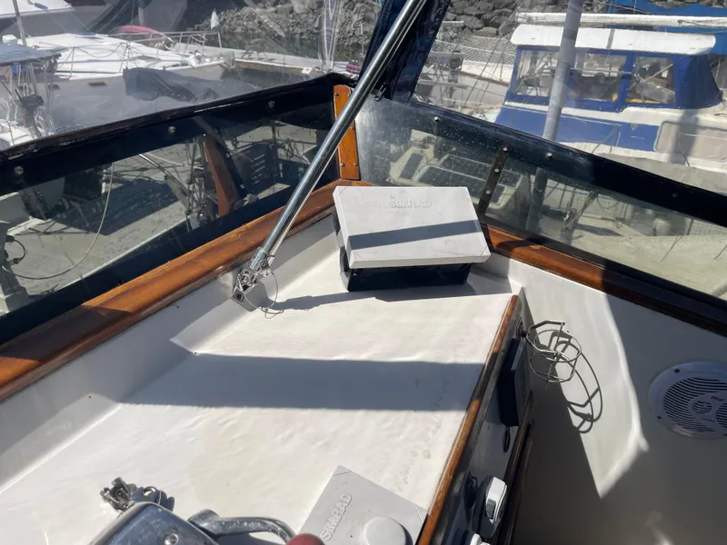 Slide: The Image of 1978 Californian Tri-Cabin Trawler helm with navigation equipment and marina view. - 7