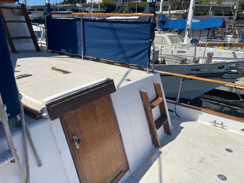 Slide: The Image of 1978 Californian Tri-Cabin Trawler deck with wooden ladder and blue canvas railing. - 9