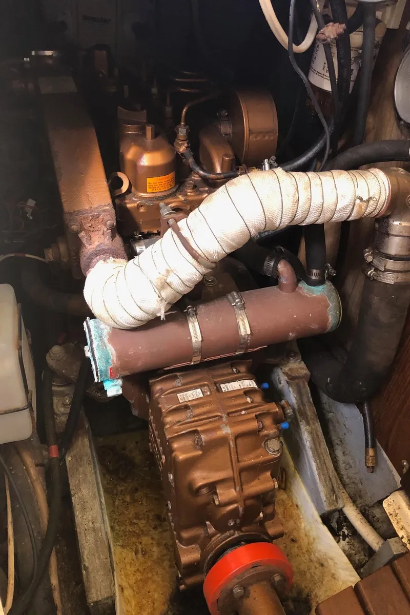 Slide: The Image of Engine room of a 1989 Nonsuch 33 sailboat, showcasing mechanical components and piping. - 10