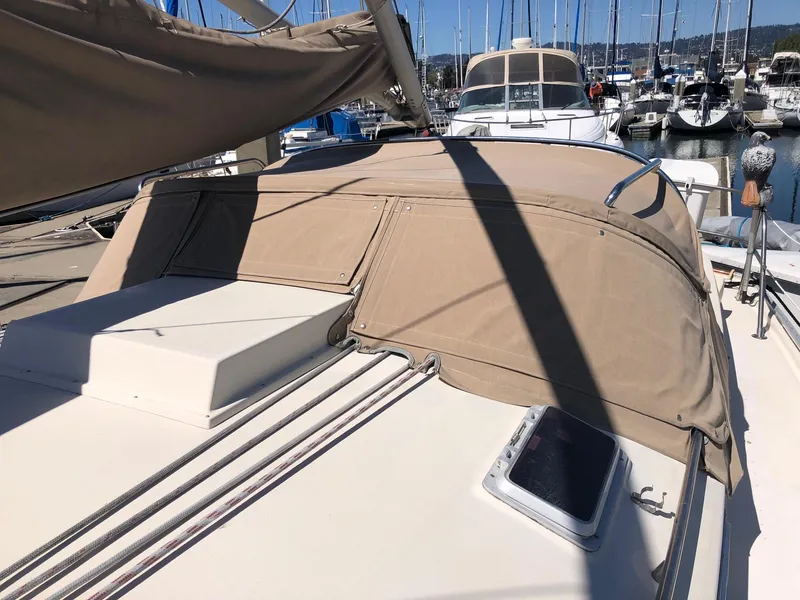 Slide: The Image of 1989 Nonsuch 33 sailboat with beige canvas cover docked at marina. - 12