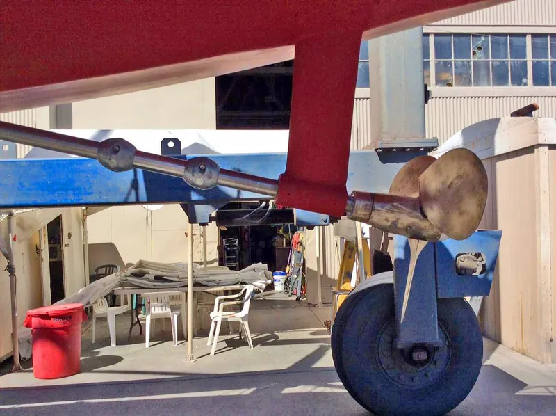 Slide: The Image of 1989 Nonsuch 33 sailboat propeller and rudder in a boatyard setting. - 17
