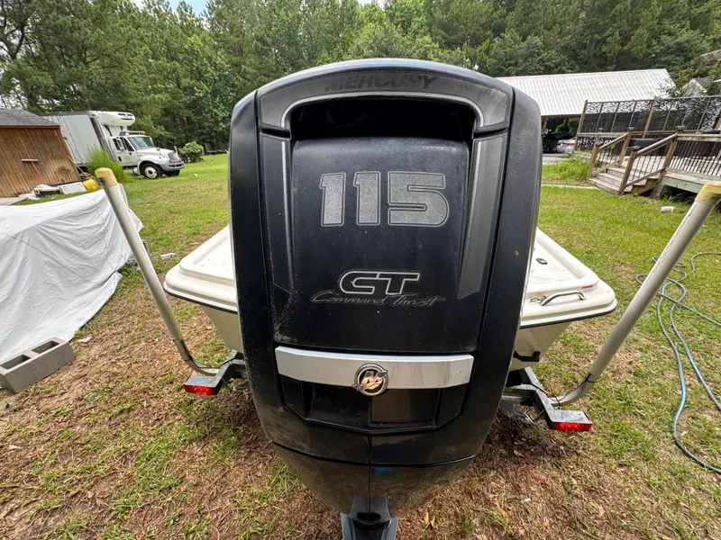Slide: The Image of 2017 Mako Pro Skiff 19 CC with Mercury 115 outboard engine in a grassy yard. - 12