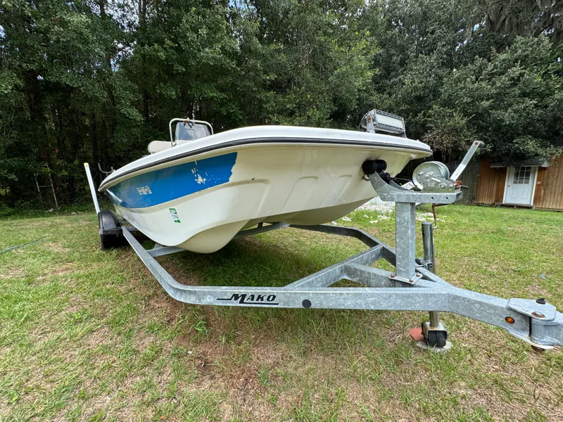 Slide: The Image of 2017 Mako Pro Skiff 19 CC boat on trailer, parked on grass. - 14