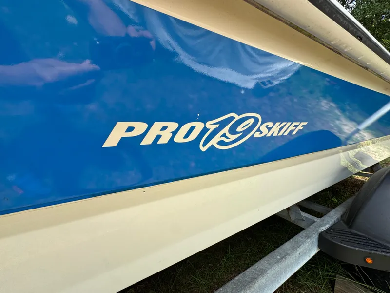 Slide: The Image of 2017 Mako Pro Skiff 19 CC boat with blue and white hull. - 2
