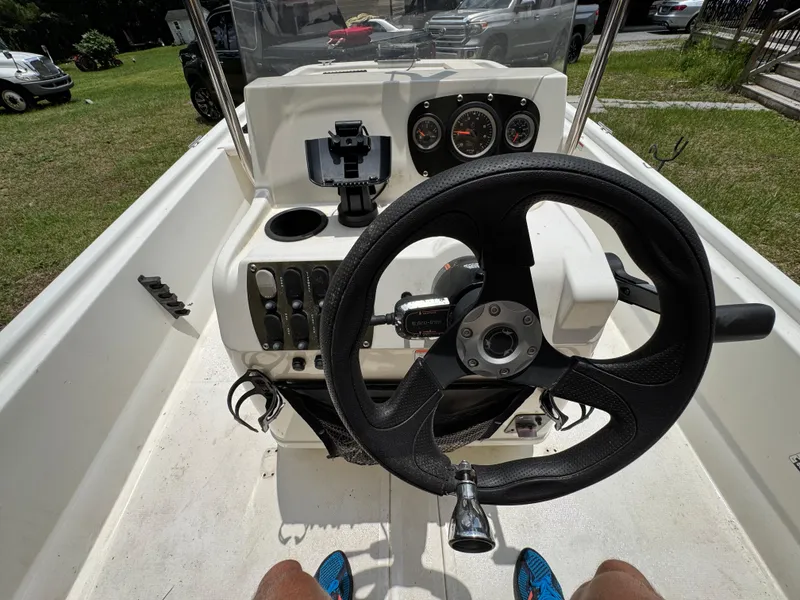 Slide: The Image of 2017 Mako Pro Skiff 19 CC boat dashboard with steering wheel and gauges. - 8