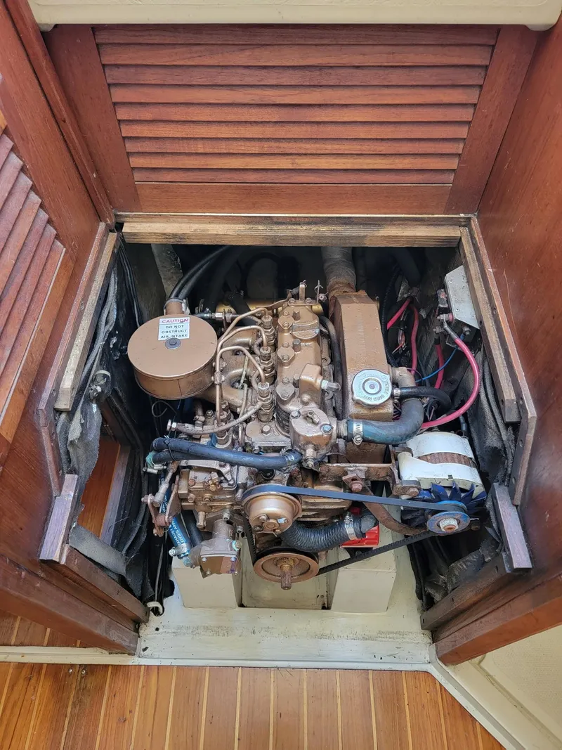 Slide: The Image of Engine compartment of a 1986 Catalina 34 sailboat, showcasing mechanical components and wiring. - 35