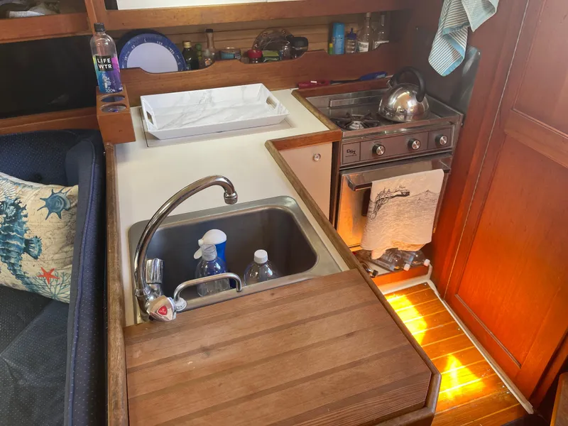Slide: The Image of Compact kitchen area in a 1986 Catalina 34 sailboat with sink and stove. - 39