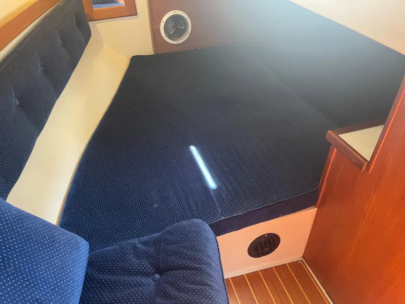 Slide: The Image of Interior cabin of 1986 Catalina 34 sailboat with blue cushioned seating. - 40