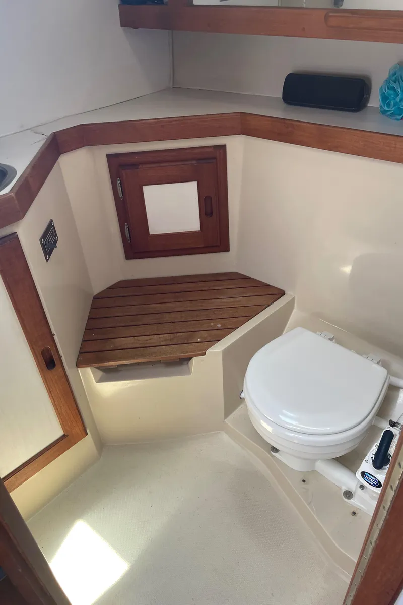 Slide: The Image of 1986 Catalina 34 boat bathroom with wooden accents and compact toilet. - 47