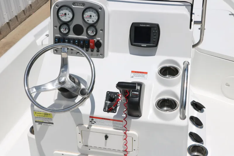 Slide: The Image of 2011 Sea Hunt XP-21 boat console with steering wheel, gauges, and controls. - 16