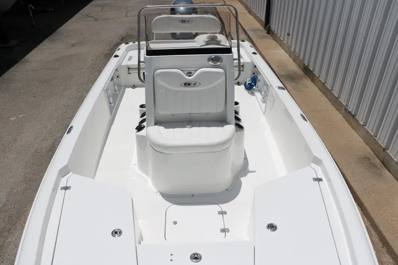 Slide: The Image of 2011 Sea Hunt XP-21 boat, white interior, docked beside a metal building. - 19
