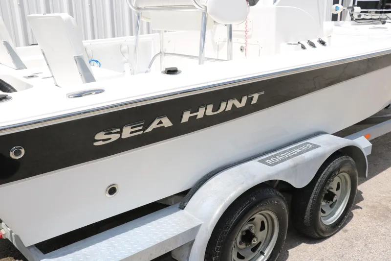 Slide: The Image of 2011 Sea Hunt XP-21 boat on trailer, side view with visible logo. - 34