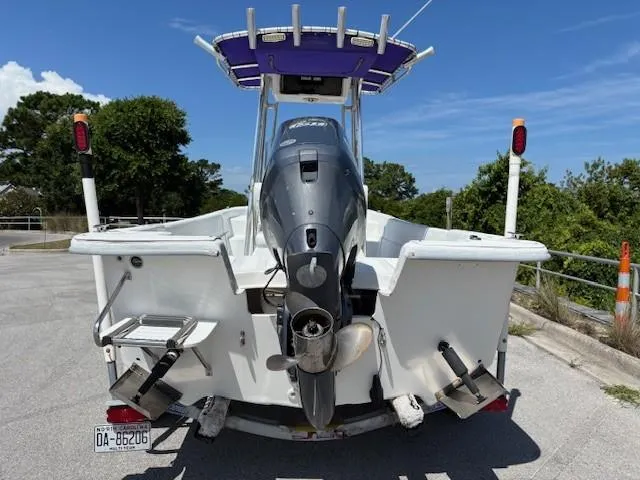 Slide: The Image of 2008 Carolina Skiff 218DLV boat with outboard motor, parked on a sunny day. - 4