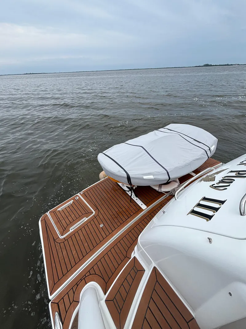 Slide: The Image of 2008 Formula 45 Yacht with surfboard on deck, overlooking calm waters. - 25