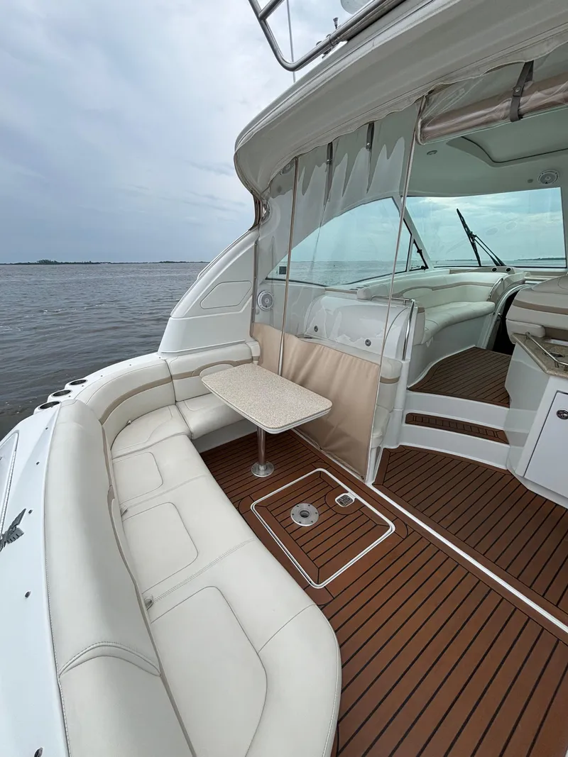 Slide: The Image of 2008 Formula 45 Yacht interior with white seating and wooden flooring, overlooking calm waters. - 29