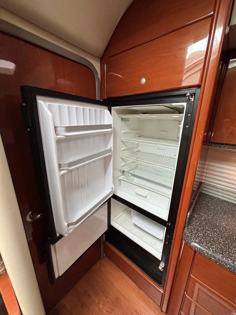 Slide: The Image of Open refrigerator inside 2008 Formula 45 Yacht, featuring wooden cabinetry and granite countertop. - 55