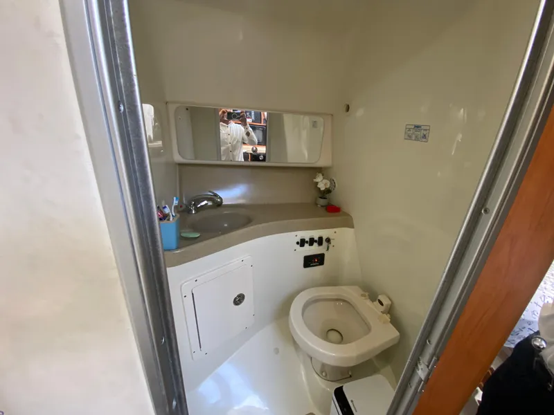 Slide: The Image of Compact bathroom in 2006 Hydra-Sports Vector 3300 VX boat, featuring sink, toilet, and mirror. - 15