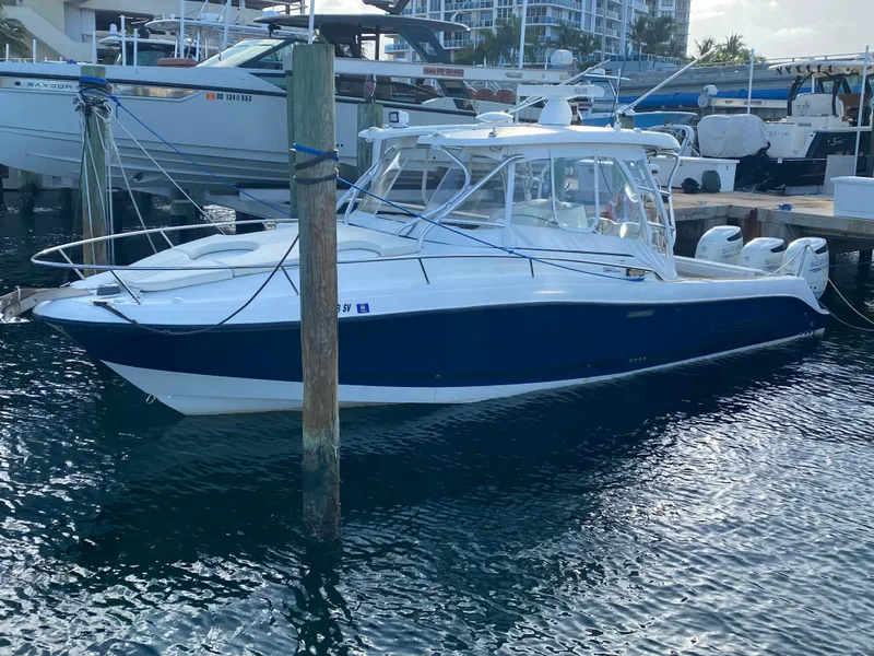 Slide: The Image of 2006 Hydra-Sports Vector 3300 VX boat docked in marina, featuring sleek design and blue hull. - 4