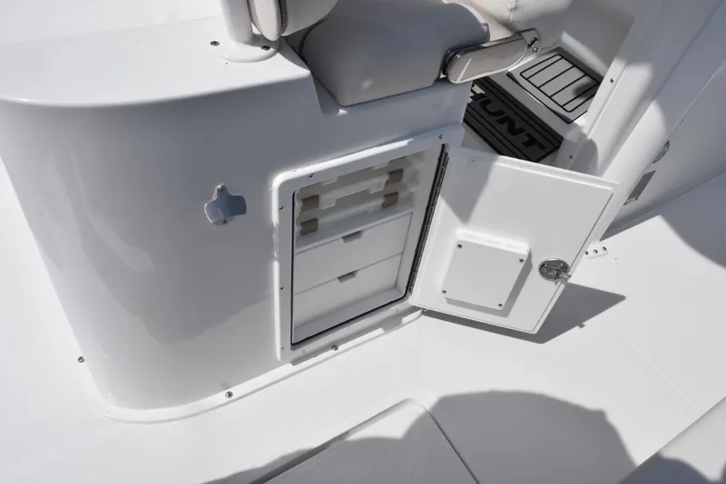 Slide: The Image of 2026 Sea Hunt Gamefish 27 Forward Seating storage compartment with open door, showcasing interior drawers. - 25