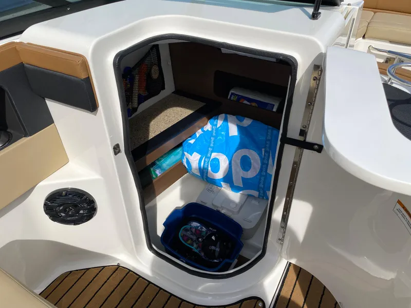 Slide: The Image of Storage compartment on 2015 Sea Ray 240 Sundeck boat with various items inside. - 10