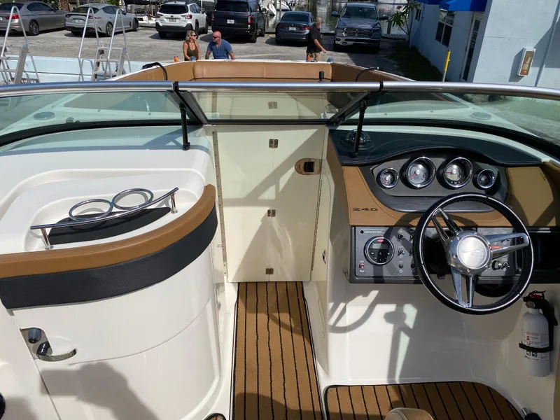 Slide: The Image of 2015 Sea Ray 240 Sundeck interior with steering wheel and dashboard controls. - 11