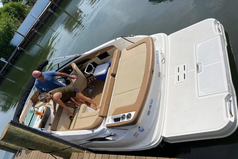 Slide: The Image of 2015 Sea Ray 240 Sundeck boat docked with two people onboard. - 17