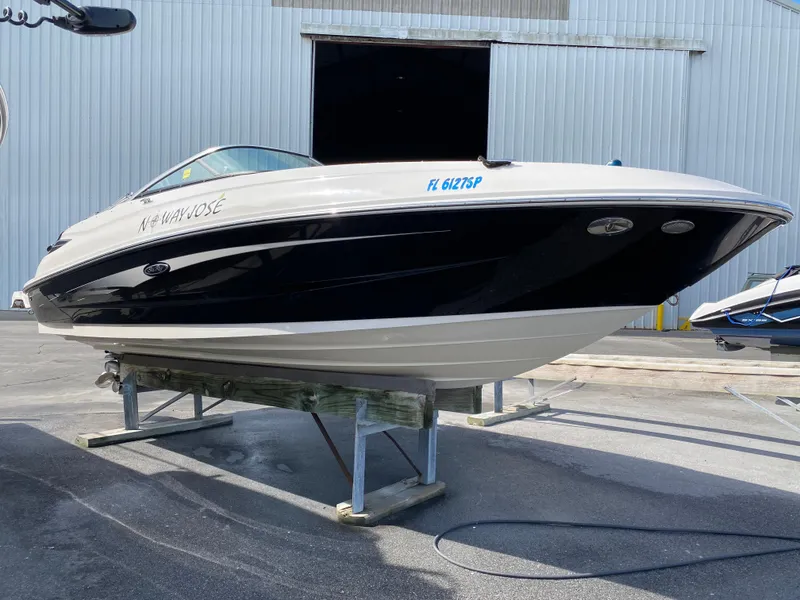 Slide: The Image of 2015 Sea Ray 240 Sundeck boat on a stand at a marina. - 2