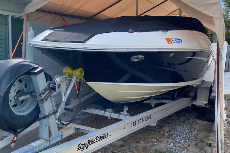 Slide: The Image of 2015 Sea Ray 240 Sundeck boat on trailer under canopy. - 20