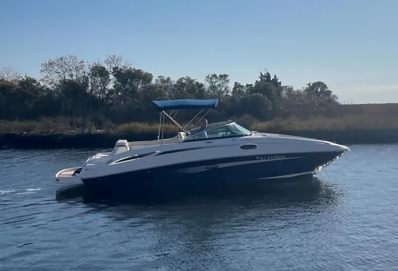 The Image of 2013 Sea Ray 260 Sundeck boat cruising on a calm river. - 0