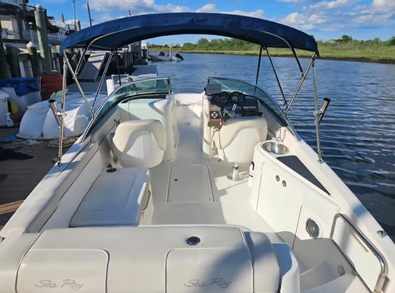 Slide: The Image of 2013 Sea Ray 260 Sundeck boat with blue canopy on calm water. - 17