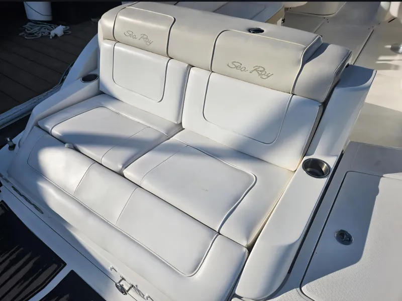 Slide: The Image of 2013 Sea Ray 260 Sundeck boat seating with cup holders, featuring white upholstery. - 21