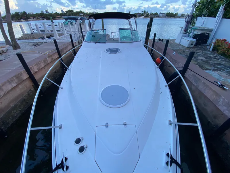 Slide: The Image of 2002 Cruisers Yachts 3372 Express docked by a scenic waterfront. - 10