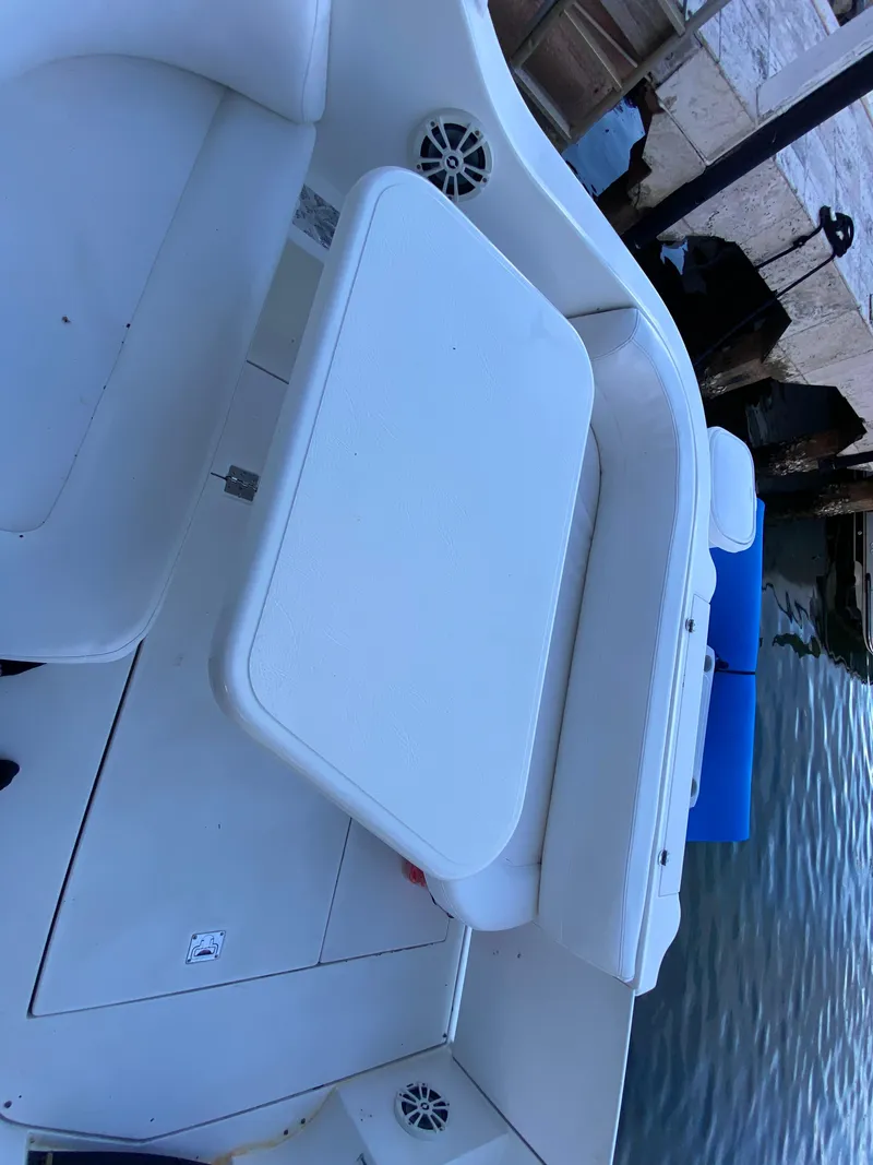 Slide: The Image of 2002 Cruisers Yachts 3372 Express boat interior with white seating and table by the water. - 12