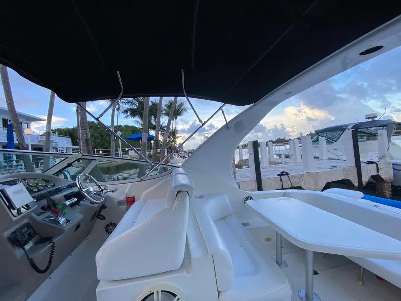 Slide: The Image of 2002 Cruisers Yachts 3372 Express interior with helm, seating, and marina view. - 16