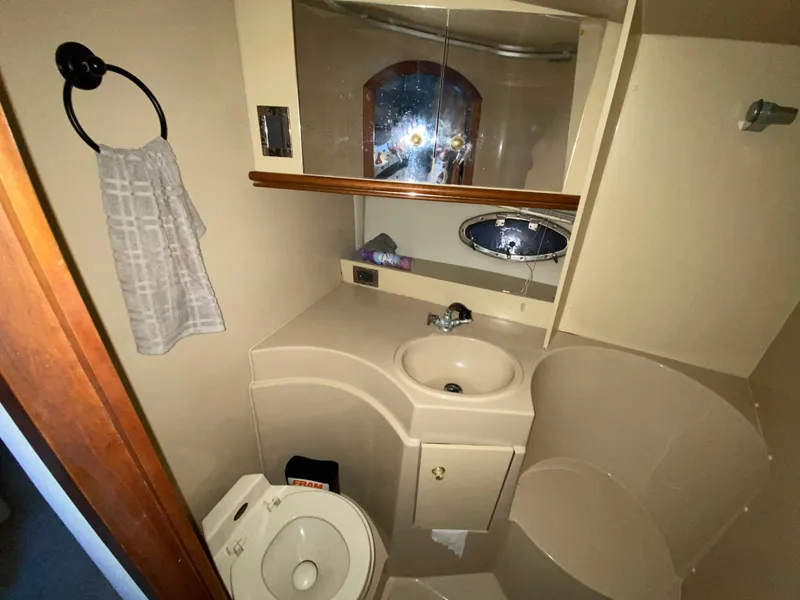 Slide: The Image of 2002 Cruisers Yachts 3372 Express bathroom with sink, toilet, and mirror. - 19