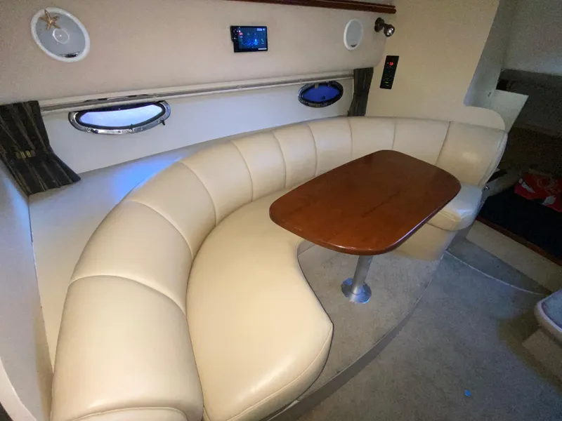 Slide: The Image of 2002 Cruisers Yachts 3372 Express interior with curved seating and wooden table. - 20