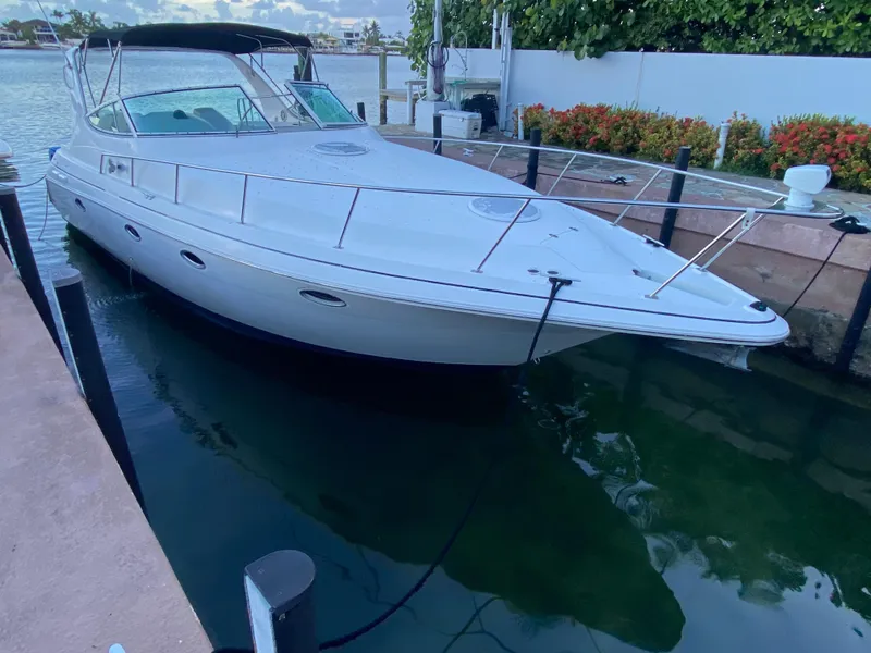 Slide: The Image of 2002 Cruisers Yachts 3372 Express docked by waterfront, showcasing sleek design and spacious deck. - 3