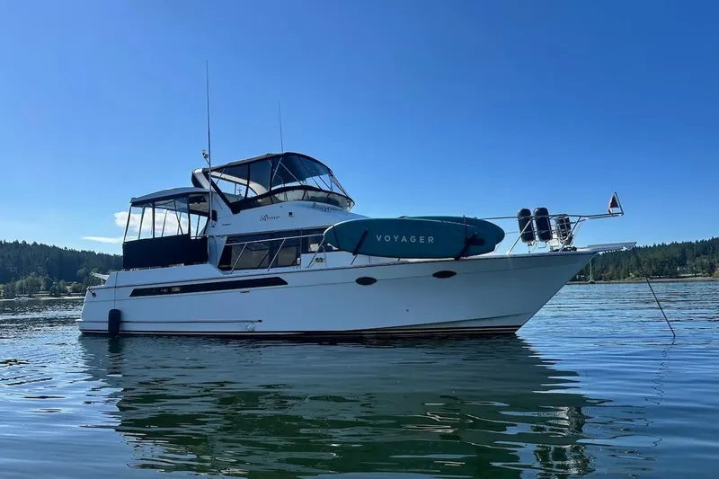 Slide: The Image of 1993 Ocean Alexander 460 yacht anchored on calm water under clear blue sky. - 1
