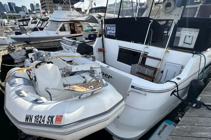 Slide: The Image of 1993 Ocean Alexander 460 yacht docked with inflatable boat, for sale sign visible. - 13