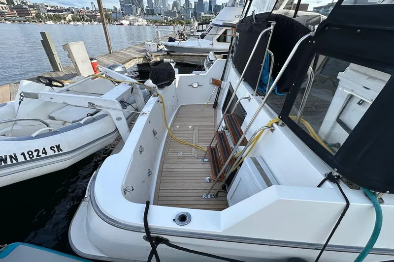 Slide: The Image of 1993 Ocean Alexander 460 yacht docked, featuring spacious deck and city skyline backdrop. - 14