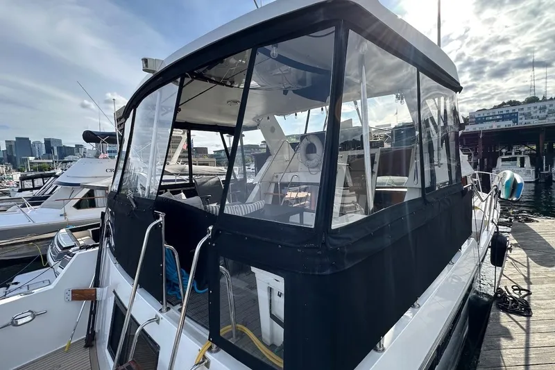 Slide: The Image of 1993 Ocean Alexander 460 yacht docked at marina, featuring enclosed cockpit and city skyline backdrop. - 18