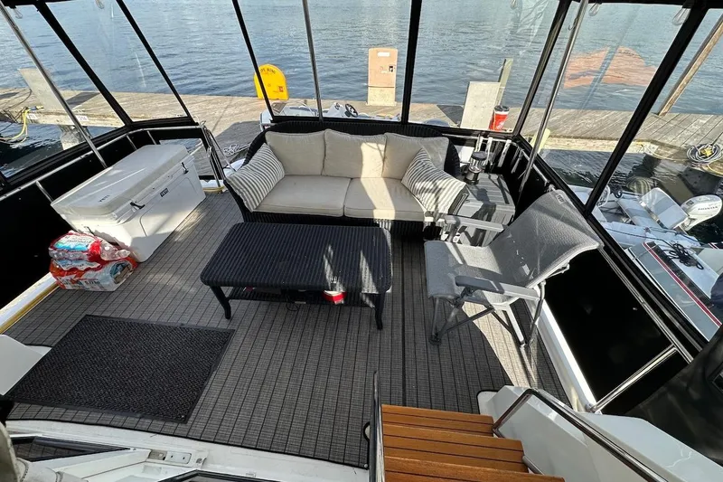 Slide: The Image of Cozy seating area on 1993 Ocean Alexander 460 yacht, docked by the water. - 21