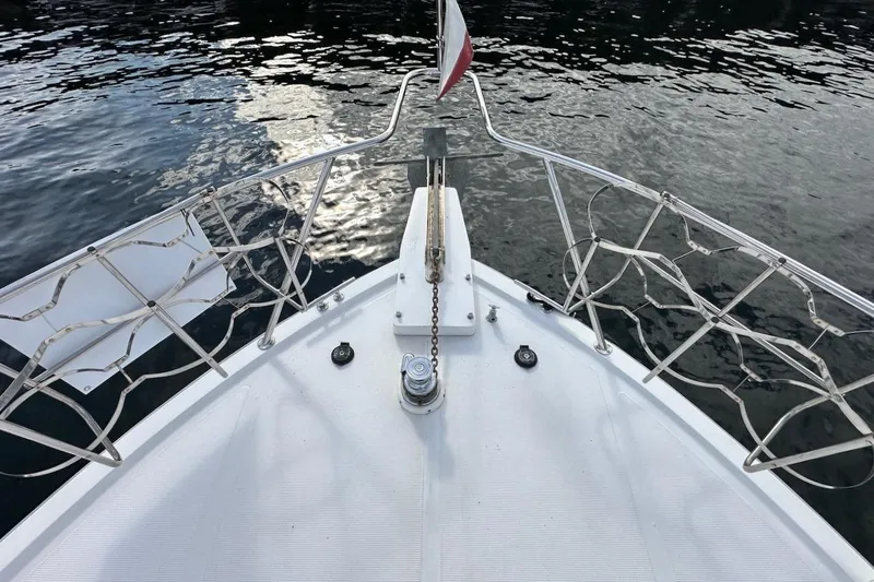 Slide: The Image of Bow view of 1993 Ocean Alexander 460 yacht with metal railings and water reflection. - 29